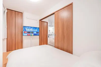 a bedroom with a bed and a sliding glass door at Waseda BNB Shinjuku in Tokyo