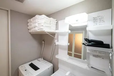 a bathroom with a washing machine and a mirror at \u30bb\u30ec\u30b9\u516b\u5e83101\u5ba4 24\u5e7410\u6708\u65b0\u305f\u306b\u30aa\u30fc\u30d7\u30f3 \u516b\u5e83\u99c5\u5f92\u6b699\u5206 \u53ce\u5bb9\u4eba\u65708 \u8cb8\u5207 \u5bdd\u5ba42 in Tokyo