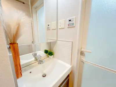 a white bathroom with a sink and a mirror at Shinjuku Downtown BZT Free WiFi in Tokyo