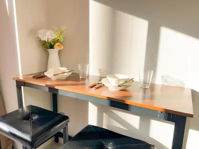 a wooden table with a vase of flowers on it at Shinjuku West Cozy WZE Free WiFi in Tokyo