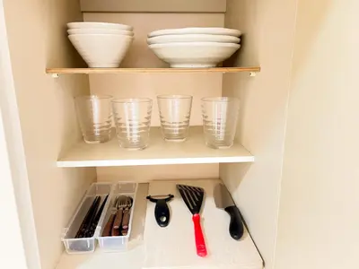 a cupboard with bowls and plates and utensils at Shinjuku West Cozy WZE Free WiFi in Tokyo