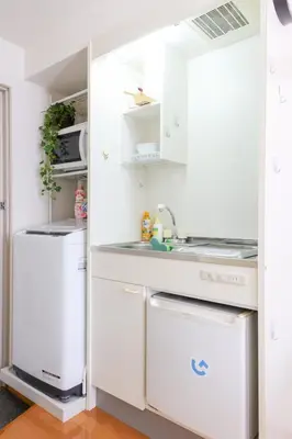 a kitchen with white cabinets and a washer and dryer at \u30cf\u30a4\u30af\u30ec\u30b9\u30c8\u4e2d\u91ce203 in Tokyo