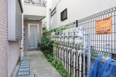 a row of parking meters on the side of a building at \u30cf\u30a4\u30af\u30ec\u30b9\u30c8\u4e2d\u91ce203 in Tokyo