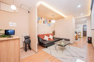 a living room with a black couch and a table at Jone\u53d9\u5712\u5546\u5e97\u8857\u8fd1\u96a3\u99c5\u5f92\u6b655\u5206 \u65b0\u5bbf12\u5206 in Tokyo