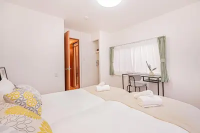 two beds in a white room with a desk at Jone\u53d9\u5712\u5546\u5e97\u8857\u8fd1\u96a3\u99c5\u5f92\u6b655\u5206 \u65b0\u5bbf12\u5206 in Tokyo