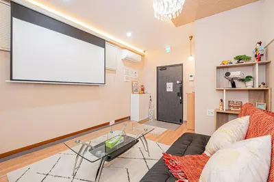 a living room with a couch and a large screen at Jone\u53d9\u5712\u5546\u5e97\u8857\u8fd1\u96a3\u99c5\u5f92\u6b655\u5206 \u65b0\u5bbf12\u5206 in Tokyo
