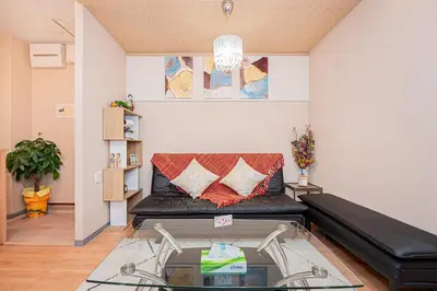 a living room with a black couch and a glass table at Jone\u53d9\u5712\u5546\u5e97\u8857\u8fd1\u96a3\u99c5\u5f92\u6b655\u5206 \u65b0\u5bbf12\u5206 in Tokyo