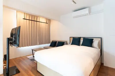 a bedroom with a large bed and a television at Lega land\u4e2d\u91ce\u5bcc\u58eb\u898b\u753a in Tokyo