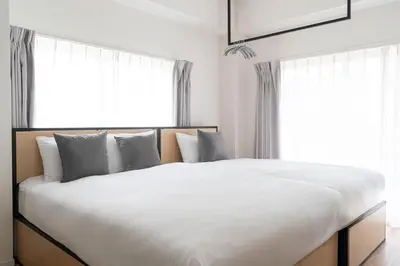a bedroom with a large white bed with windows at \u30c0\u30fc\u30a6\u30a3\u30f3\u795e\u697d\u5742 in Tokyo