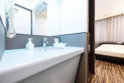 a bathroom with a sink and a mirror and a bed at Hotel Grand Fort - Vacation STAY 19307v in Tokyo