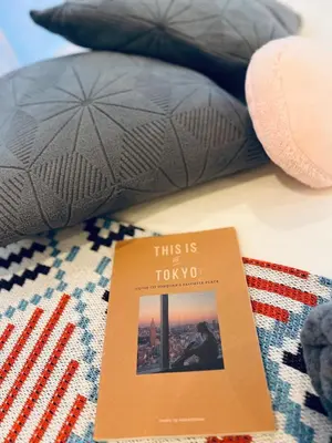 a book sitting on top of a bed with pillows at High-end Tokyo shinjuku Central Park Flat 2 in Tokyo
