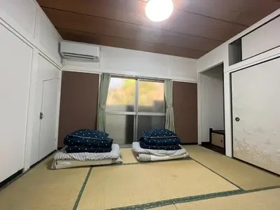 a room with three pillows on the floor with a window at \u5343\u77f3\u5bb6 in Tokyo