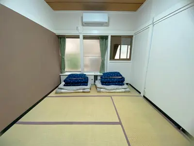 a room with two blue pillows and a window at \u5343\u77f3\u5bb6 in Tokyo