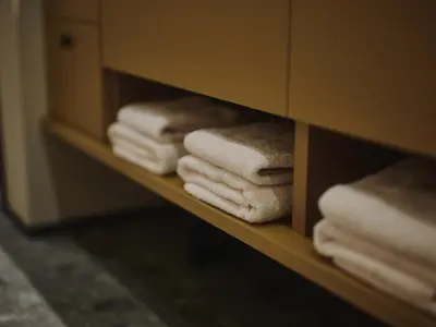 a shelf filled with towels in a bathroom at illi Gran Azabujuban in Tokyo