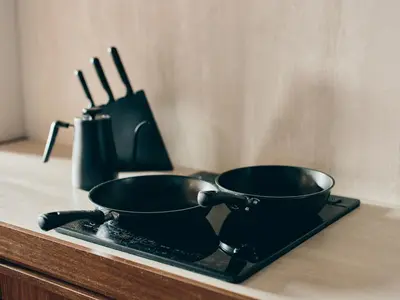 two frying pans sitting on a tray on a counter at illi Gran Azabujuban in Tokyo