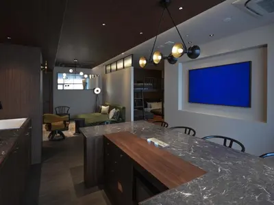 a living room with a kitchen with a tv on the wall at illi Gran Azabujuban in Tokyo