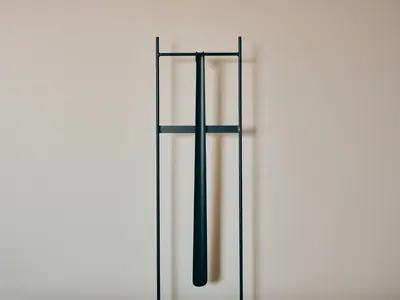 a white wall with two black poles on it at illi Gran Azabujuban in Tokyo