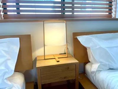 a lamp on a night stand next to two beds at \u6e0b\u8c37\u99c5\u5f92\u6b6910\u5206!!\u4e00\u68df\u307e\u308b\u3054\u3068\u8cb8\u3057\u5207\u308a!\u304a\u5b50\u69d8\u6b53\u8fce\u99d0\u8eca\u5834\u7121\u659910\u4ebaok5\u90e8\u5c4b\u30d0\u30b9\u30eb\u30fc\u30e02\u3064 in Tokyo