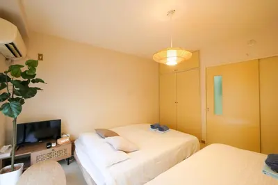 a small room with two beds and a television at #4 -\u30a8\u30af\u30bb\u30eb\u6a4b\u7acb102- Entire Unit in Tokyo