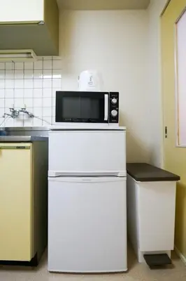 a microwave on top of a white refrigerator in a kitchen at #4 -\u30a8\u30af\u30bb\u30eb\u6a4b\u7acb102- Entire Unit in Tokyo