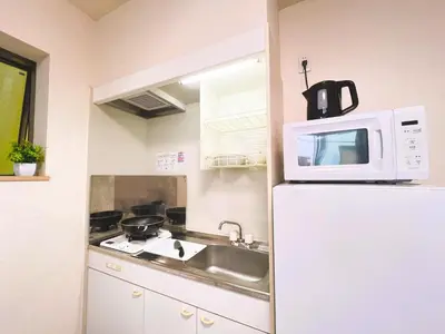a kitchen with a microwave on top of a refrigerator at Ueno Cozy Loft Apt Free WiFi in Tokyo