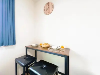 a table with two stools and a clock on a wall at Ueno Cozy Loft Apt Free WiFi in Tokyo