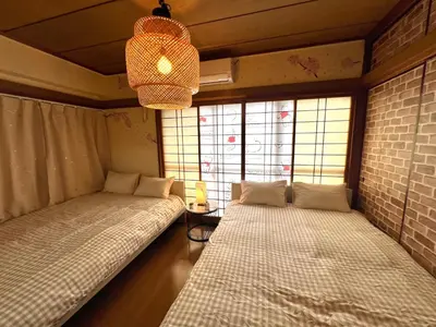 two beds in a room with windows and a chandelier at \u5927\u4e45\u4fdd4\u5206\u65b0\u5927\u4e45\u4fdd8\u5206\u30c6\u30e9\u30b9\u4ed8\u304d in Tokyo