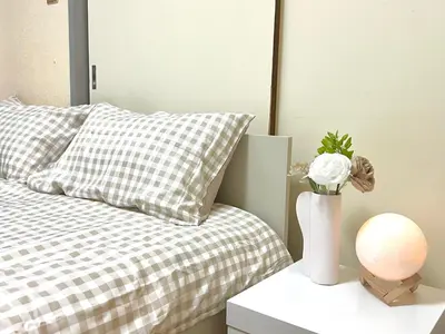 a bedroom with a bed and a vase with flowers on a table at \u5927\u4e45\u4fdd4\u5206\u65b0\u5927\u4e45\u4fdd8\u5206\u30c6\u30e9\u30b9\u4ed8\u304d in Tokyo