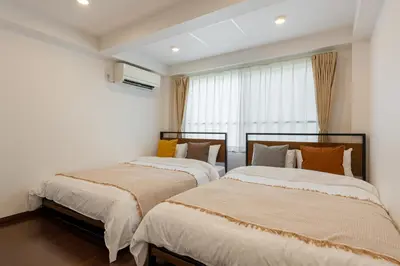 two beds in a room with white walls at \u4ee3\u3005\u6728\u4e0a\u539f in Tokyo