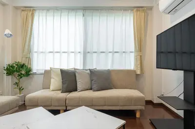 a living room with a couch in front of a window at \u4ee3\u3005\u6728\u4e0a\u539f in Tokyo