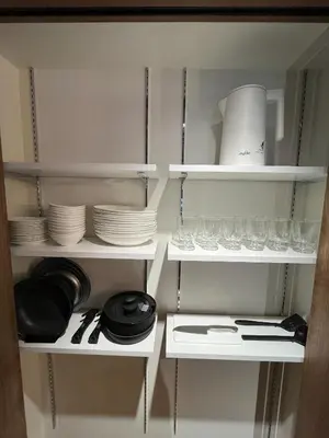 a kitchen cabinet with plates and glasses and utensils at MANGA ART HOTEL, BAKUROCHO - Vacation STAY 24887v in Tokyo