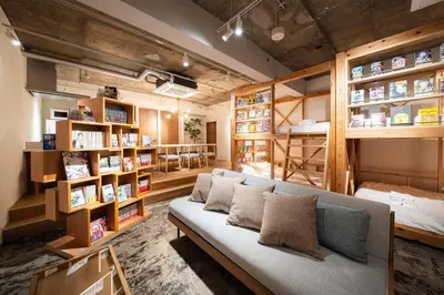 a living room with a couch and book shelves at MANGA ART HOTEL, BAKUROCHO - Vacation STAY 24863v in Tokyo