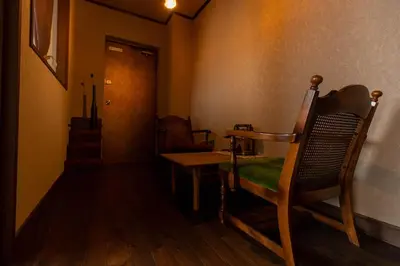 a room with a chair and a table and a door at THE HOTEL of TOKYO Akasaka in Tokyo