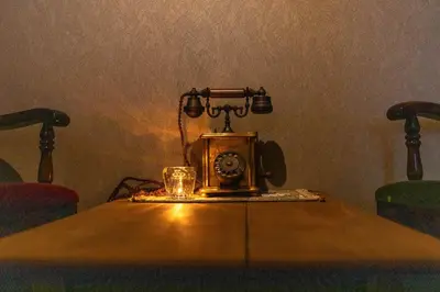 an old phone sitting on a table with a glass on it at THE HOTEL of TOKYO Akasaka in Tokyo