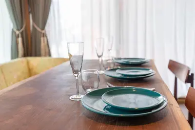 a wooden table with plates and wine glasses on it at THE HOTEL of TOKYO Akasaka in Tokyo