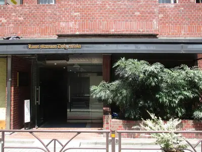 an entrance to a brick building with a tree at \u30e9\u30a4\u30aa\u30f3\u30ba\u30de\u30f3\u30b7\u30e7\u30f3\u9053\u7384\u5742c in Tokyo