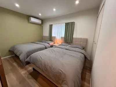 two beds in a small room with a window at \u62bc\u4e0aSkytree Oshiage Hostel-KT0032 in Tokyo