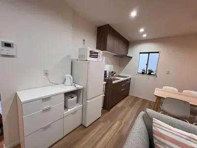 a kitchen with a white refrigerator and a table at \u62bc\u4e0aSkytree Oshiage Hostel-KT0032 in Tokyo