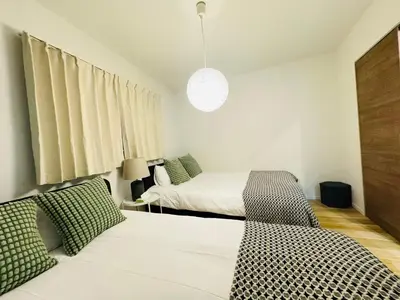 a bedroom with two beds and a couch in it at Ueno Minowa House -TT0398 in Tokyo