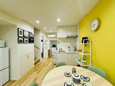 a kitchen with a table and a clock on a wall at Ueno Minowa House -TT0398 in Tokyo