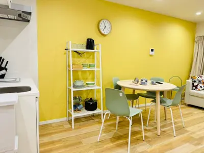 a dining room with a table and chairs and a clock at Ueno Minowa House -TT0398 in Tokyo
