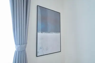 a picture hanging on a wall next to a window at FINOA Residential Suite Kamata in Tokyo