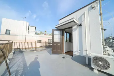 a person standing on the balcony of a building at FINOA Residential Suite Kamata in Tokyo