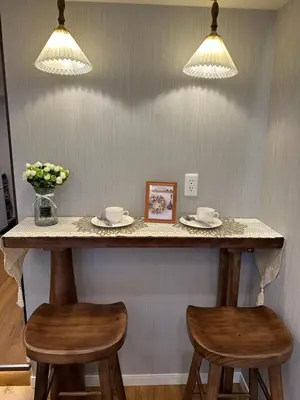 a counter with two stools and two cups and a picture at \u6da9\u8c37\u6c11\u5bbf in Tokyo