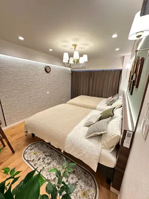 a bedroom with a large bed and a chandelier at \u6da9\u8c37\u6c11\u5bbf in Tokyo