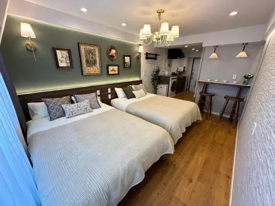 a bedroom with two beds and a kitchen in it at \u6da9\u8c37\u6c11\u5bbf in Tokyo