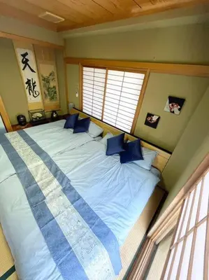 a bedroom with a large bed with blue pillows at \u30a2\u30f3\u30c9\u30b9\u30c6\u30a4\u84b2\u75301\u4e01\u76ee in Tokyo