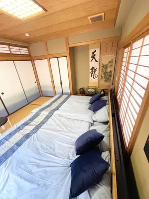 a large bed in a room with windows at \u30a2\u30f3\u30c9\u30b9\u30c6\u30a4\u84b2\u75301\u4e01\u76ee in Tokyo