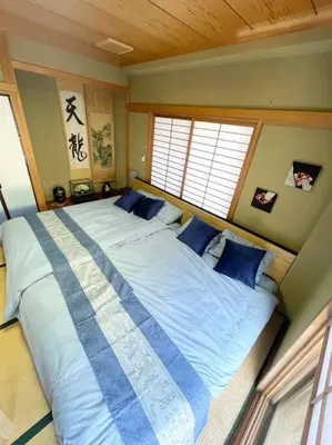 a bedroom with a large bed with blue pillows at \u30a2\u30f3\u30c9\u30b9\u30c6\u30a4\u84b2\u75301\u4e01\u76ee in Tokyo