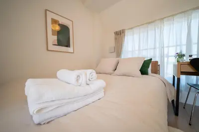 a bedroom with a bed with towels on it at Ken's Place Omotesando in Tokyo